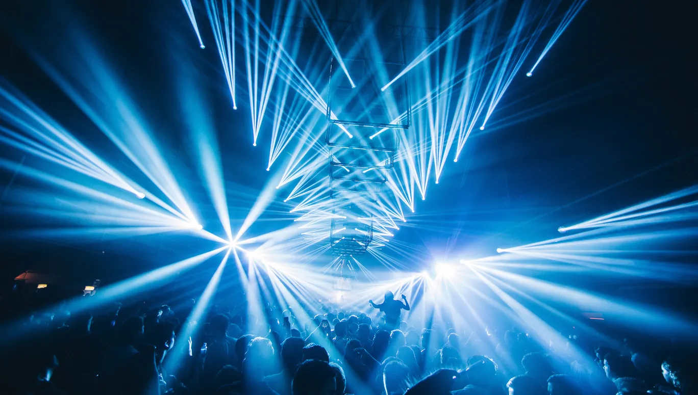 People on the dancefloor under the blue disco lights.