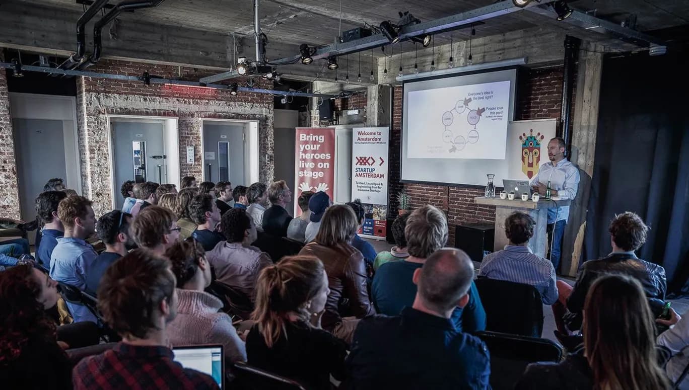Someone presents on stage at a StartupAmsterdam event.