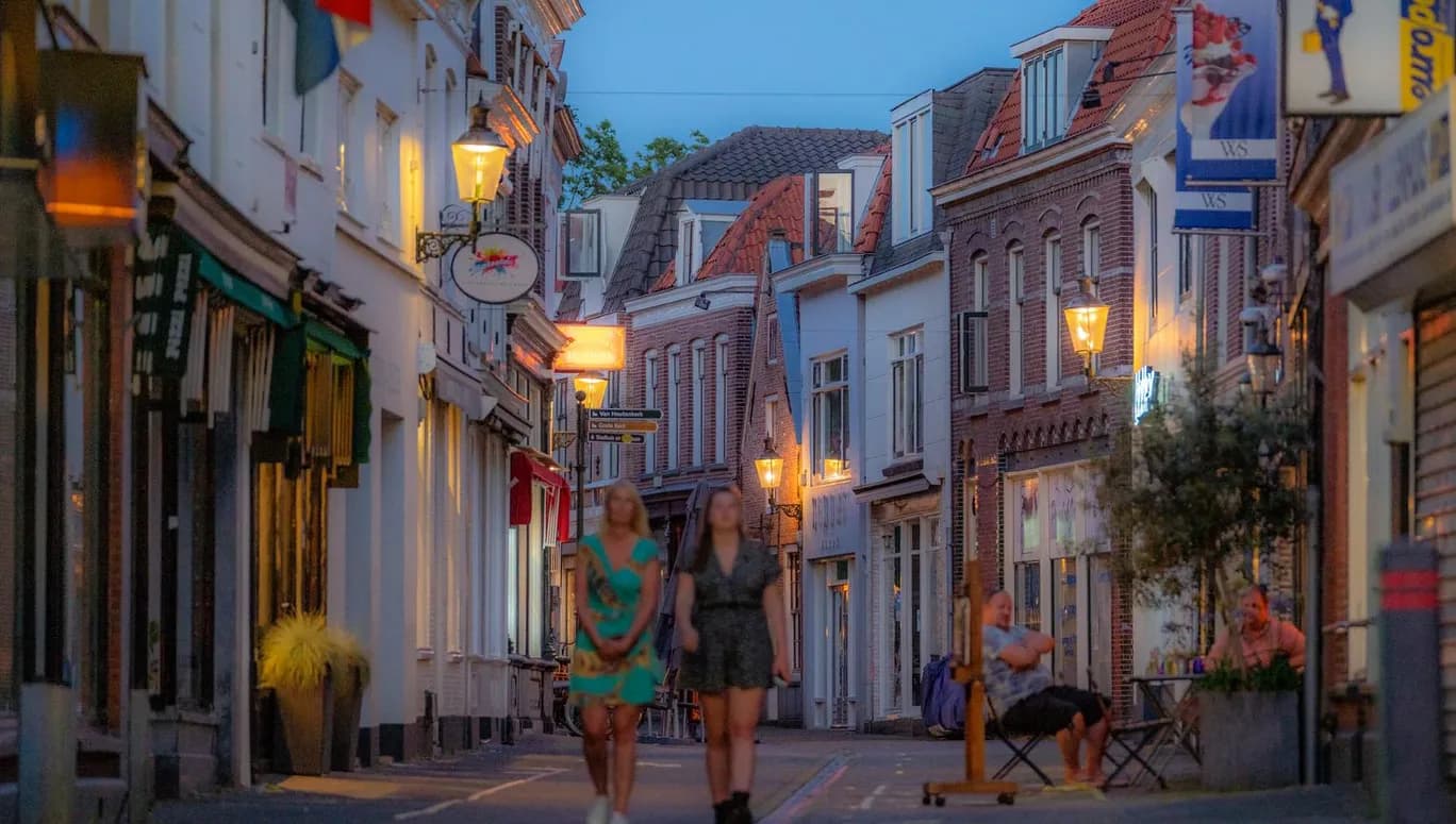 People walking through the streets of Weesp at night
