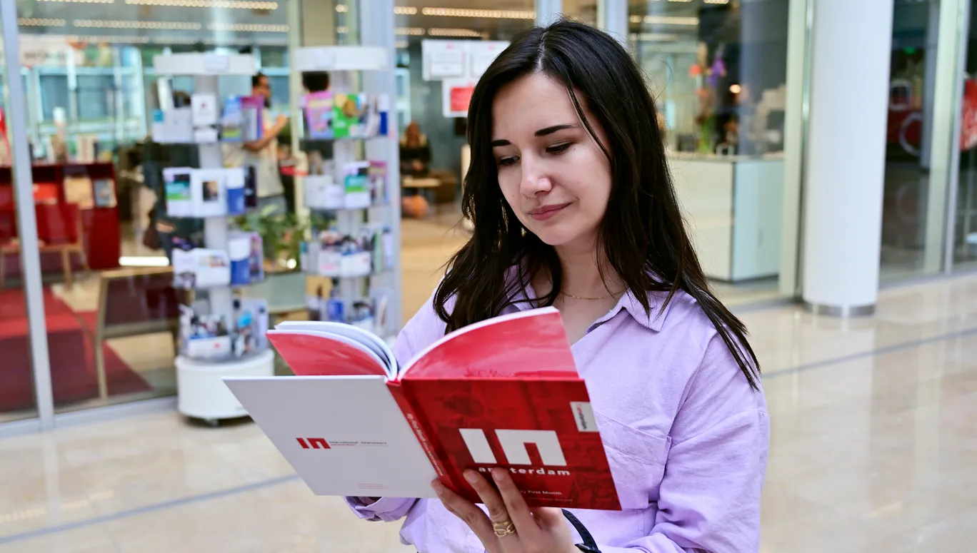 Woman reading the IN Amsterdam book.