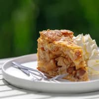 Selective focus of a piece of apple pie on white plate served with whipping cream on the side, Homemade apple pie on wooden table with blurred green garden background.
1787711810
Typically Dutch foods