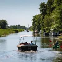 A boat passing trough the water of the Groene Hart.