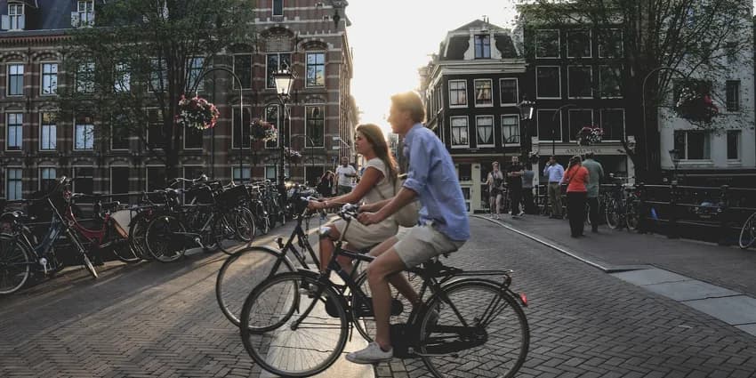 Two people biking through Amsterdam