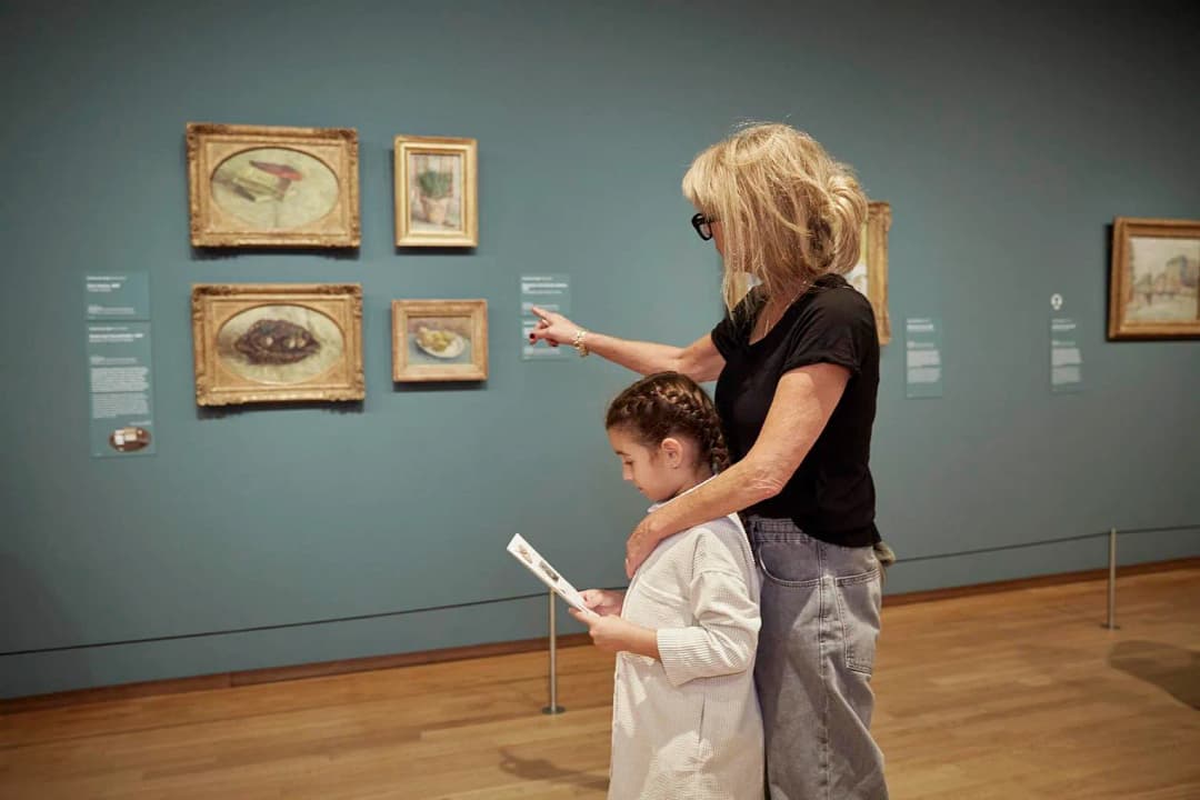 An adult and a girl are visiting Van Gogh Museum.