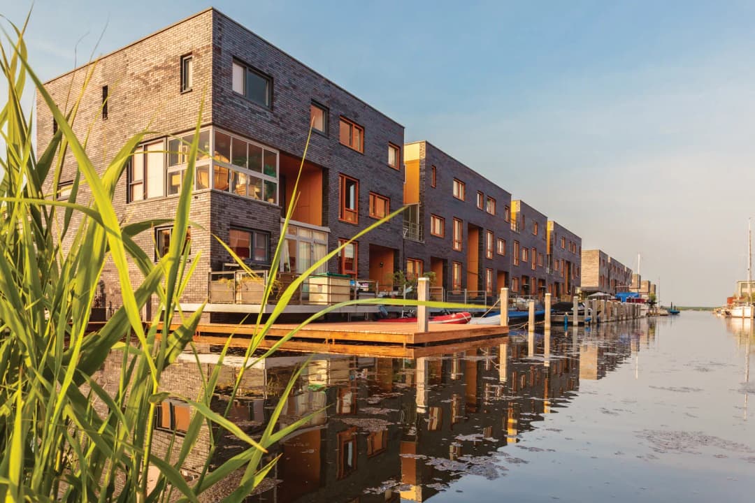 Row of Dutch modern canal houses in Almere reflected in the water