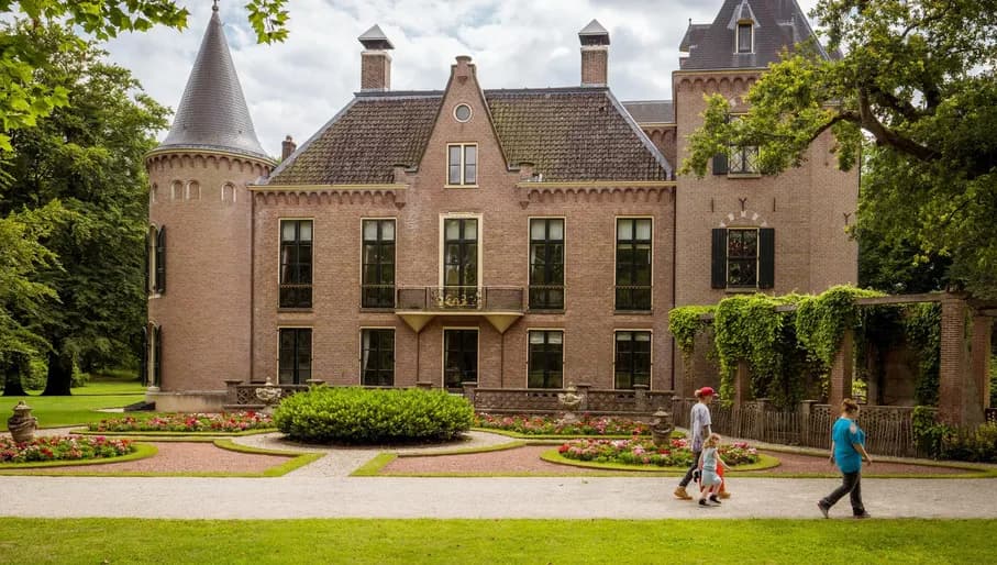 Two women and a child walking next to Keukenhof Castle.