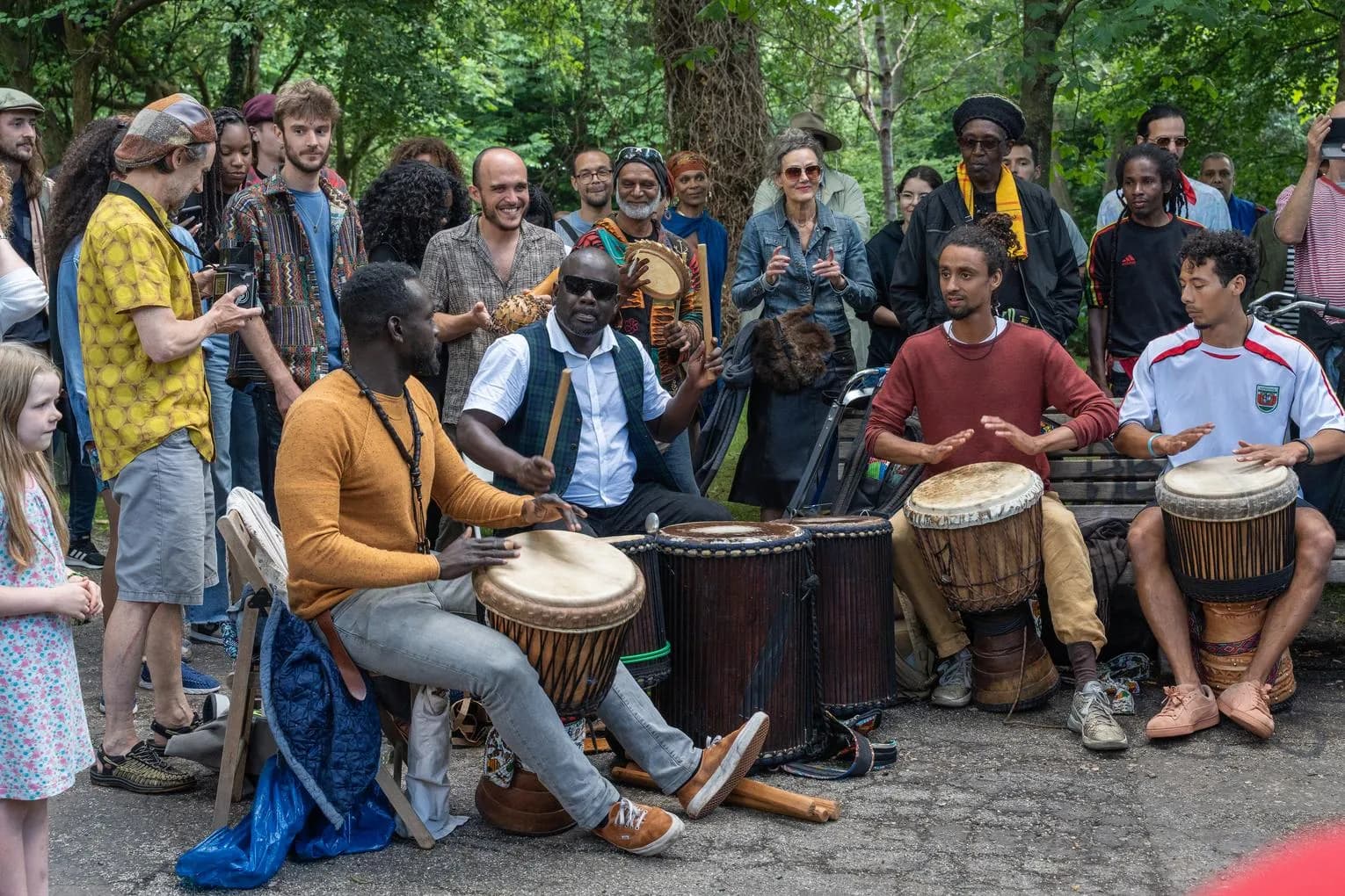 Musicians playing djembe while spectators watching and listening during Keti Koti Festival 2022 in the Oosterpark.