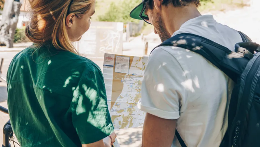 A couple looking at a Amsterdam cycle seeing map