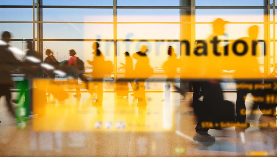 Schiphol airport information sign seen through glass window.