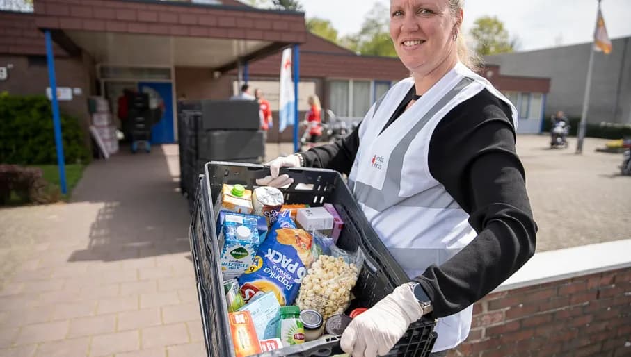 Een Ready2Helper van het Rode Kruis ondersteunt bij de voedselbank. De reguliere vrijwilligers van de voedselbank vallen veelal in de risicogroepen waardoor zij zich nu niet kunnen inzetten. Het Rode Kruis ondersteunt zodat mensen toch hun voedselpakketten kunnen ophalen.