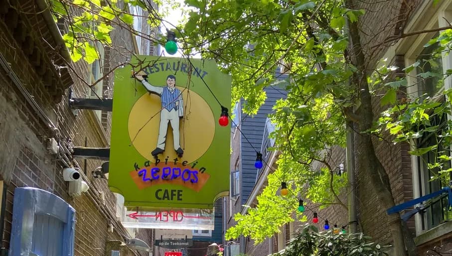 Restaurant Kapitein Zeppos Centrum, alley with terrace and people. Sign of Kapitein Zeppos