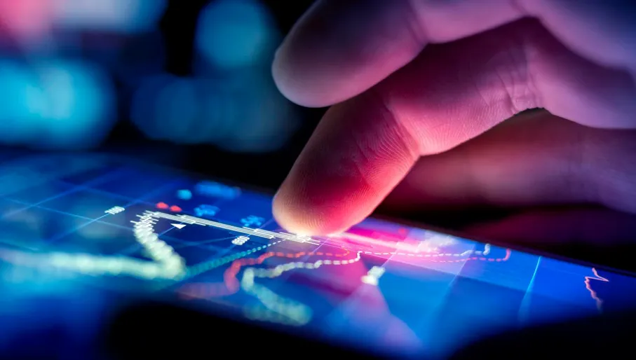 A city businessman using a mobile device to check stocks and market data. Close up shot.