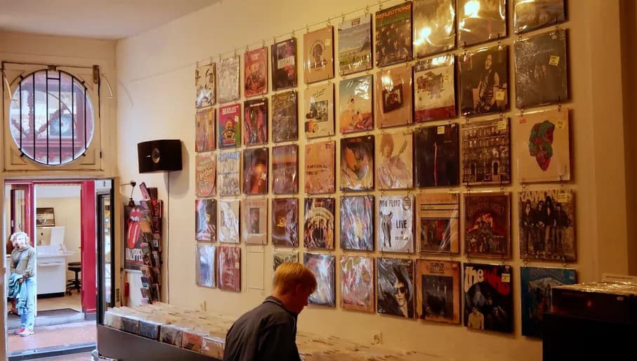 Waxwell records 1: two people outside of the records shop under an umbrella
Waxwell records 2 & 3: bike outside the shop
Waxwell records 4: woman looking at a vinyl inside the shop
Waxwell records 5: records player inside the shop
Waxwell records 6: person looking through the vinyl inside the shop
Waxwell records 7: owner and her dog inside the shop
Waxwell records 8: mirror inside reflecting the shop
Waxwell records 9: dog of the owner inside the shop